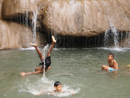 Local children enjoying the pool at the foot of the waterfall